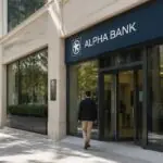 Symbolbild: Eingang einer Bankfiliale in einer griechischen Stadt mit Passanten
