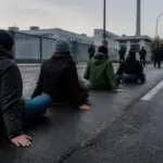 Συμβολική απεικόνιση διαδηλωτών καθισμένων στο οδόστρωμα έξω από βιομηχανικές εγκαταστάσεις στο Βερολίνο