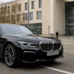 Συμβολική εικόνα μαύρης BMW Σειράς 7 έξω από δημόσιο κτίριο στη Γερμανία, για την απόσυρση προσφοράς leasing