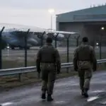 Στρατιωτικοί της Bundeswehr περιπολούν σε στρατιωτικό αεροδρόμιο δίπλα σε υπόστεγο και αεροσκάφος.
