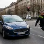 Συμβολική απεικόνιση αυτοκινήτου Ford κοντά σε αστυνομικό της Τροχαίας σε διασταύρωση στη Δρέσδη