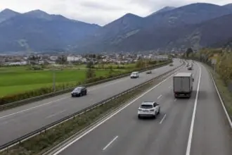 Κυκλοφορία αυτοκινήτων και φορτηγού σε ελβετικό αυτοκινητόδρομο με φόντο αλπικό τοπίο