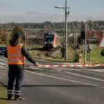 Συμβολική εικόνα δύο εργαζομένων που αποκλείουν με κόκκινη και λευκή ταινία μια σιδηροδρομική διάβαση στη Βαυαρία