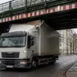Συμβολική απεικόνιση φορτηγού ακινητοποιημένου κάτω από σιδηροδρομική γέφυρα σε γερμανική πόλη
