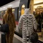 Δύο άνδρες με λούτρινες στολές σε αποβάθρα δίπλα σε νυχτερινό τρένο, συμβολική απεικόνιση του περιστατικού στην Ερφούρτη