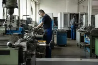 Εργαζόμενοι σε γερμανικό βιομηχανικό εργαστήριο με μηχανήματα παραγωγής, στο πλαίσιο των ιταλικών εξαγορών.