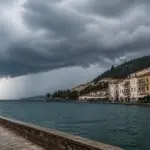 Symbolische Wetteraufnahme einer dunklen Gewitterfront über einer Küstenstadt in Griechenland