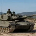 Griechischer Leopard-Kampfpanzer auf einem staubigen militärischen Übungsgelände