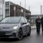Συμβολική εικόνα ηλεκτρικού αυτοκινήτου Volkswagen μπροστά σε βιομηχανικές εγκαταστάσεις στο Βόλφσμπουργκ
