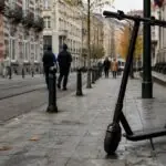 Ηλεκτρικό πατίνι σε πεζοδρόμιο των Βρυξελλών, με πεζούς και αστυνομικούς στο βάθος