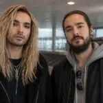 Οι Bill και Tom Kaulitz σε συμβολική απεικόνιση αεροδρομίου με άδειο ιμάντα αποσκευών