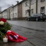 Συμβολική εικόνα με λουλούδια στη μνήμη νεαρού δίπλα σε δρόμο κατοικημένης περιοχής της Κολωνίας