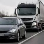 Επιβατικό αυτοκίνητο κοντά σε διαχωριστική γραμμή λωρίδων με φορτηγό σε γερμανικό δρόμο, σε συμβολική εικόνα