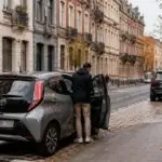 Μικρό επιβατικό αυτοκίνητο παρκαρισμένο σε αστικό δρόμο των Βρυξελλών, με μεγαλύτερα οχήματα στο βάθος.
