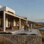 Modernes Ferienhaus an einer griechischen Küste mit Interessenten auf der Terrasse