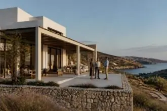 Modernes Ferienhaus an einer griechischen Küste mit Interessenten auf der Terrasse