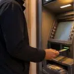 Symbolische Darstellung einer Person beim Geldabheben an einem Geldautomaten in Griechenland