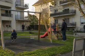 Παιδιά σε παιδική χαρά ανάμεσα σε πολυκατοικίες, συμβολική εικόνα για το Sissach της Ελβετίας