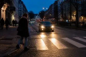 Πεζός σε διάβαση δρόμου στις Βρυξέλλες το σούρουπο, κατά τη χειμερινή ώρα