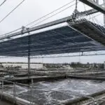 Συμβολική απεικόνιση πτυσσόμενης φωτοβολταϊκής οροφής πάνω από δεξαμενές βιολογικού καθαρισμού στη Στουτγάρδη