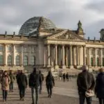 Το κτίριο του γερμανικού κοινοβουλίου Reichstag στο Βερολίνο με περαστικούς, συμβολική απεικόνιση της δημοσκόπησης για την κυβέρνηση