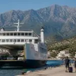 Symbolbild einer Autofähre vor der bergigen Küste der griechischen Insel Samothraki