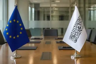 Σημαία της Ευρωπαϊκής Ένωσης απέναντι από λευκή σημαία των Ταλιμπάν σε συμβολικό χώρο συνομιλιών.