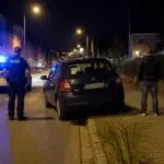 Συμβολική νυχτερινή εικόνα Skoda Fabia σε γερμανικό δρόμο με αστυνομικό περιπολικό και μπλε φάρους
