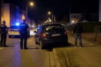 Συμβολική νυχτερινή εικόνα Skoda Fabia σε γερμανικό δρόμο με αστυνομικό περιπολικό και μπλε φάρους