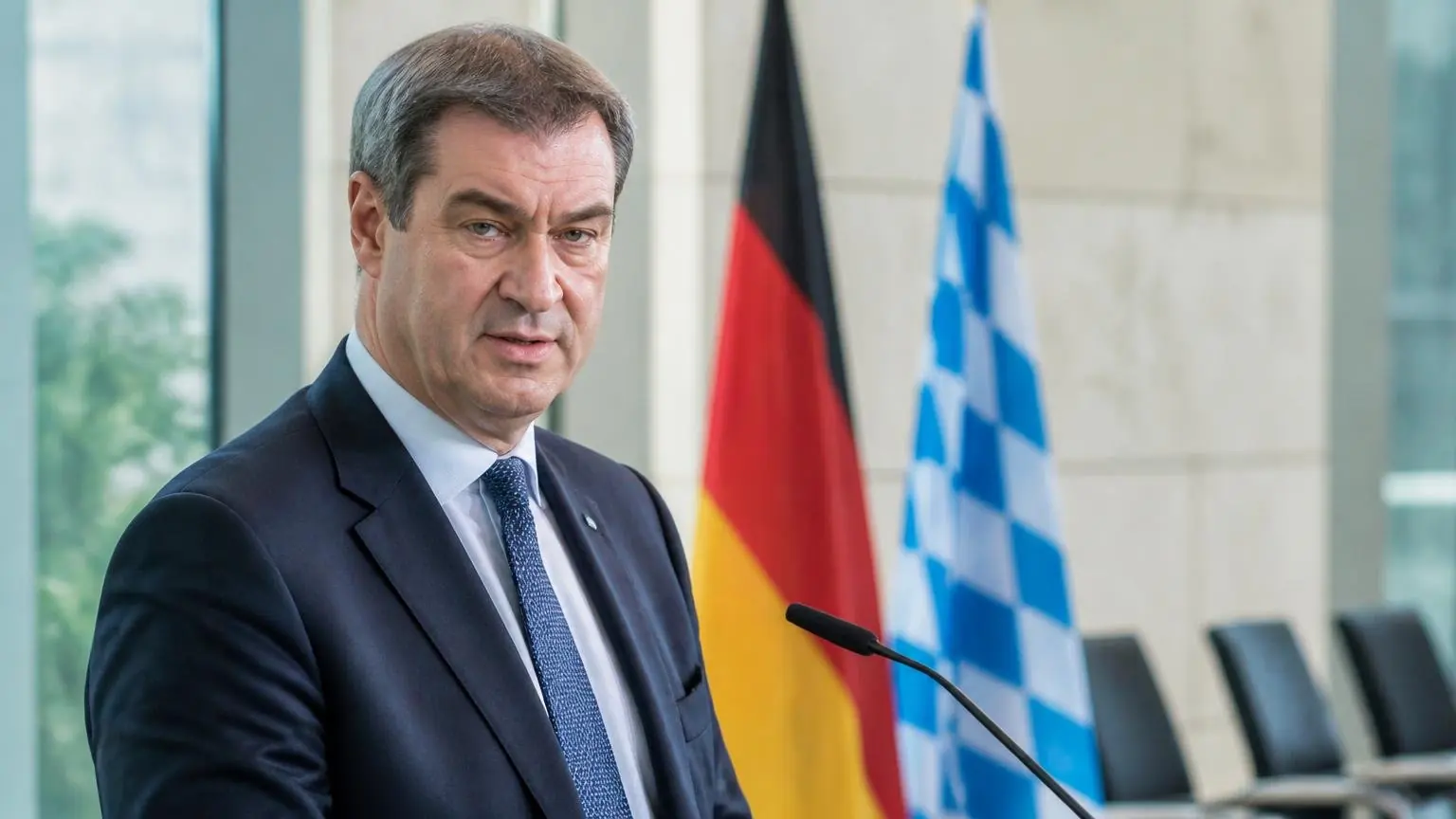 Συμβολικό πορτρέτο του Markus Söder σε γερμανικό πολιτικό περιβάλλον με σημαίες στο βάθος