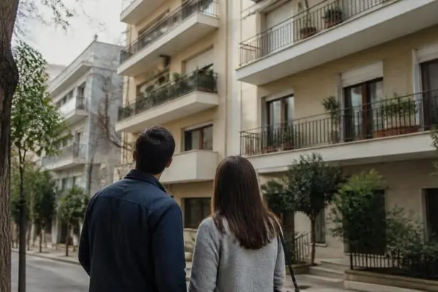 Zwei Menschen betrachten ein Wohnhaus in einem griechischen Stadtviertel.
