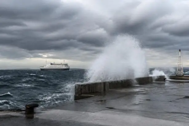 Stürmische See mit aufspritzenden Wellen an einer griechischen Fähranlegestelle.