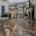 Symbolbild einer regennassen Straße auf einer griechischen Insel mit strömendem Wasser und Schlamm