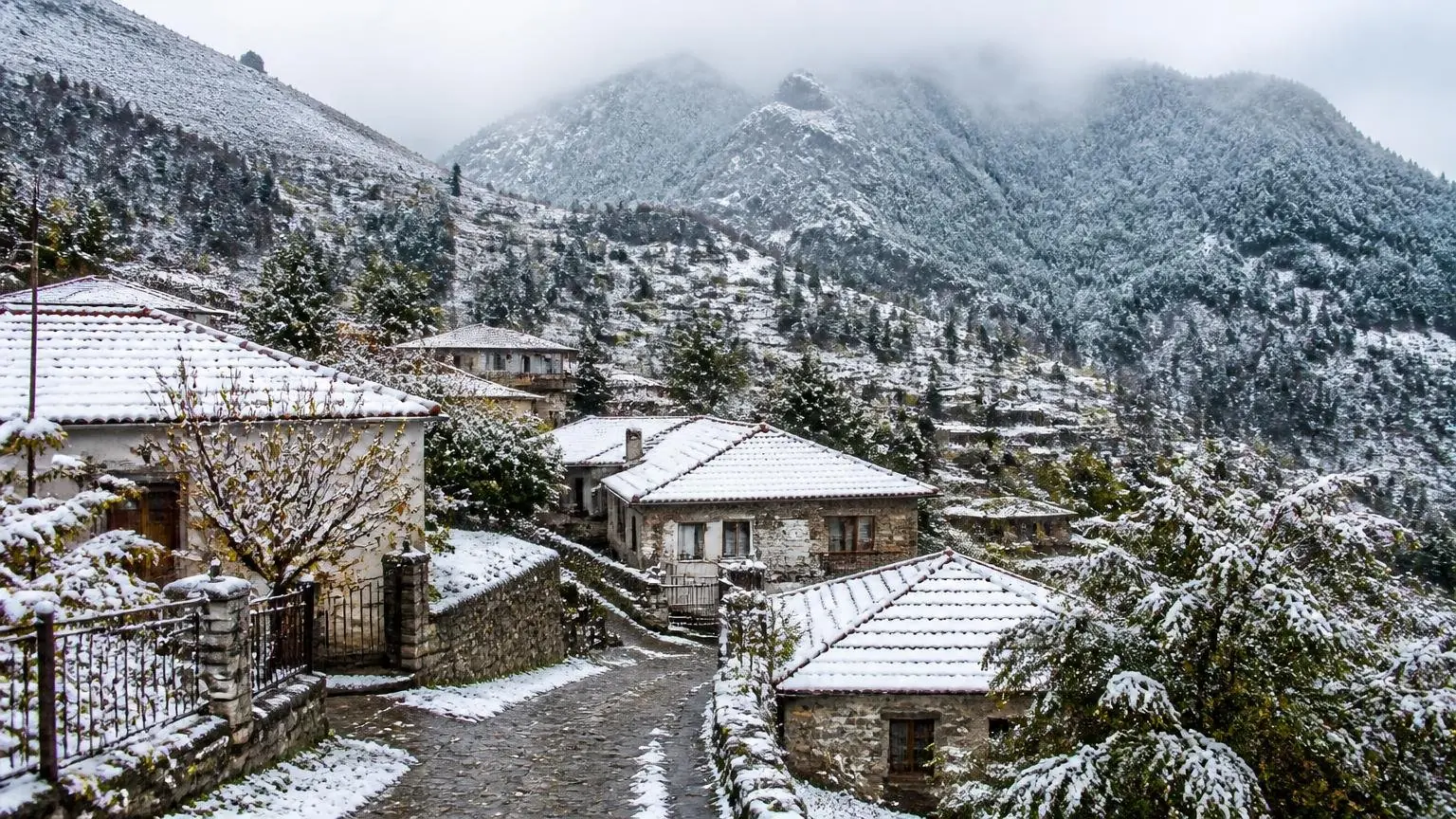 Symbolbild eines verschneiten Bergdorfs in der griechischen Berglandschaft