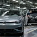 Αυτοκίνητο Volkswagen και εργαζόμενοι σε συμβολική απεικόνιση γερμανικής γραμμής παραγωγής