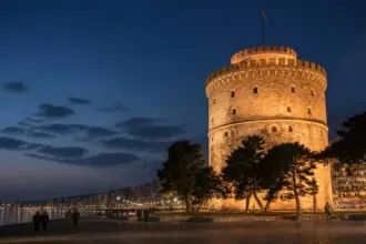 Symbolbild des abends beleuchteten Weißen Turms an der Uferpromenade von Thessaloniki