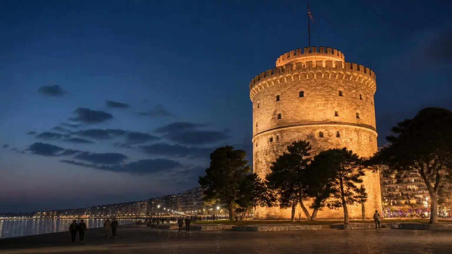 Symbolbild des abends beleuchteten Weißen Turms an der Uferpromenade von Thessaloniki