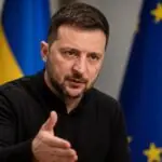 Ο Βολοντίμιρ Ζελένσκι σε συμβολική απεικόνιση με σημαίες της Ουκρανίας και της Ευρωπαϊκής Ένωσης.