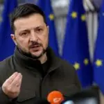 Ο Βολοντίμιρ Ζελένσκι μιλά σε δημοσιογράφους με σημαίες της ΕΕ στο φόντο.