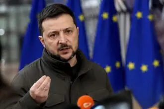 Ο Βολοντίμιρ Ζελένσκι μιλά σε δημοσιογράφους με σημαίες της ΕΕ στο φόντο.